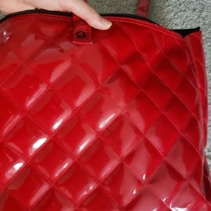 Pair of red quilted luggage bags (one with wheels, one with handles only)